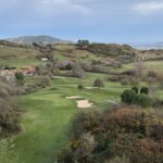 A golf green and bunkers in the rolling green hills of Spain's Basque Country