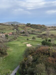 A golf green and bunkers in the rolling green hills of Spain's Basque Country