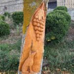 A tree carved with a fox and grapes in wine country near Laguardia