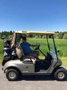 John E. Cone Jr., father of JP Cone, in a golf cart out on the course golfing with JP