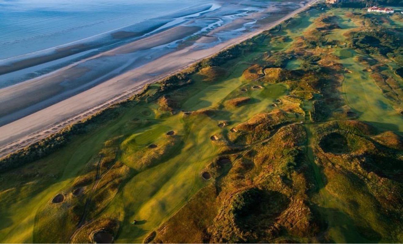 Aerial view of a links golf course running alongside a long beach