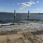 The Cais das Colunas pillars standing in the River Tagus at Praça do Comércio in Lisbon, waves washing over the river steps