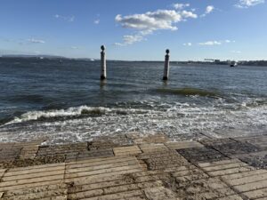 The Cais das Colunas pillars standing in the River Tagus at Praça do Comércio in Lisbon, waves washing over the river steps