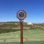 The course clock at Finca Cortesín Golf Club in Andalucia, Spain, with the fairways behind