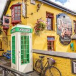 Durty Nelly's, the famous yellow pub beside Bunratty Castle, County Clare, with its old green telephone box outside