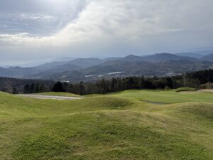 A golf course beneath layered mountain ridges in northern Spain