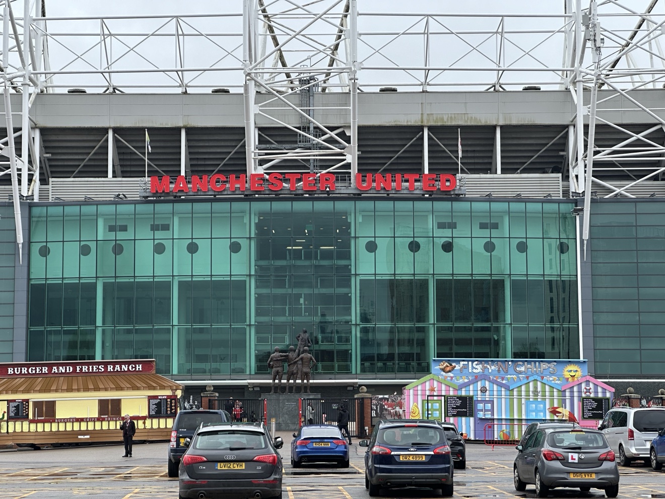 Old Trafford East Stand with the United Trinity statue, home of Manchester United