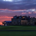 The Royal and Ancient clubhouse at St Andrews under a dramatic sunset sky
