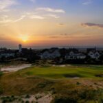 A links green at sunset beneath the houses of the Lancashire coast