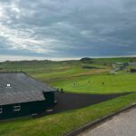 Royal Dornoch Golf Club Scotland – dramatic stormy coastline with club flagpole