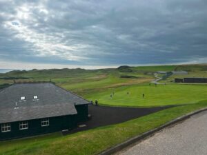 Royal Dornoch Golf Club Scotland – dramatic stormy coastline with club flagpole