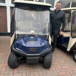 A guest beside a Royal Dublin Golf Club cart