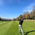 A golfer following through on a parkland fairway in northern Spain