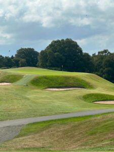 Scotland golf green with yellow flagstick surrounded by trees