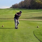 A golfer teeing off on a parkland course in northern Spain