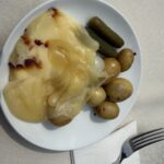A plate of raclette with potatoes and pickles, served at a Swiss food festival in New York
