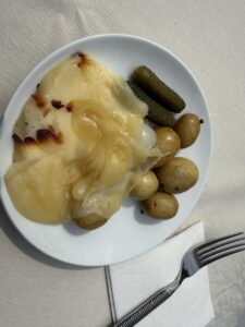 A plate of raclette with potatoes and pickles, served at a Swiss food festival in New York